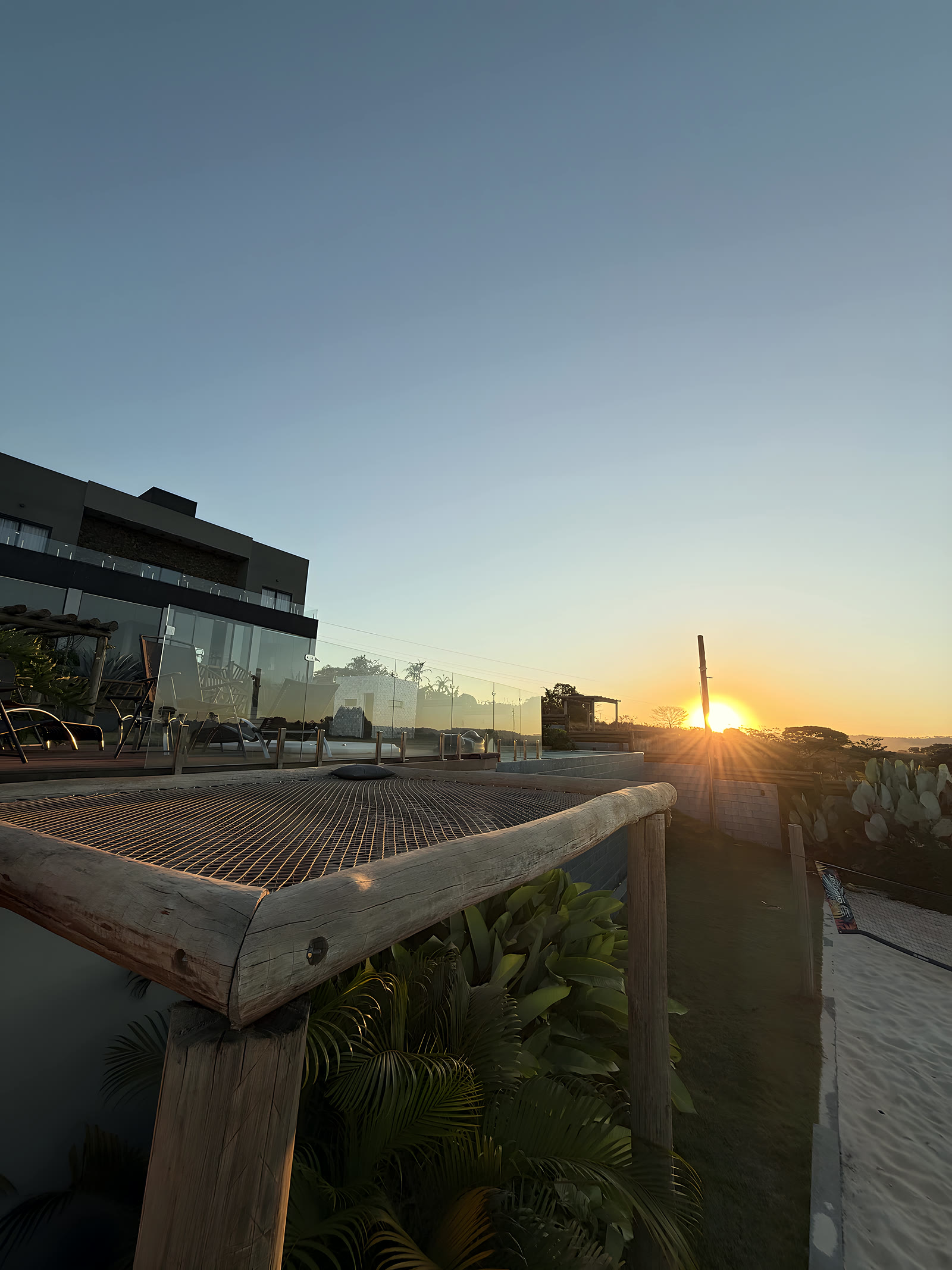Deck de madeira com o sol se pondo sobre a serra