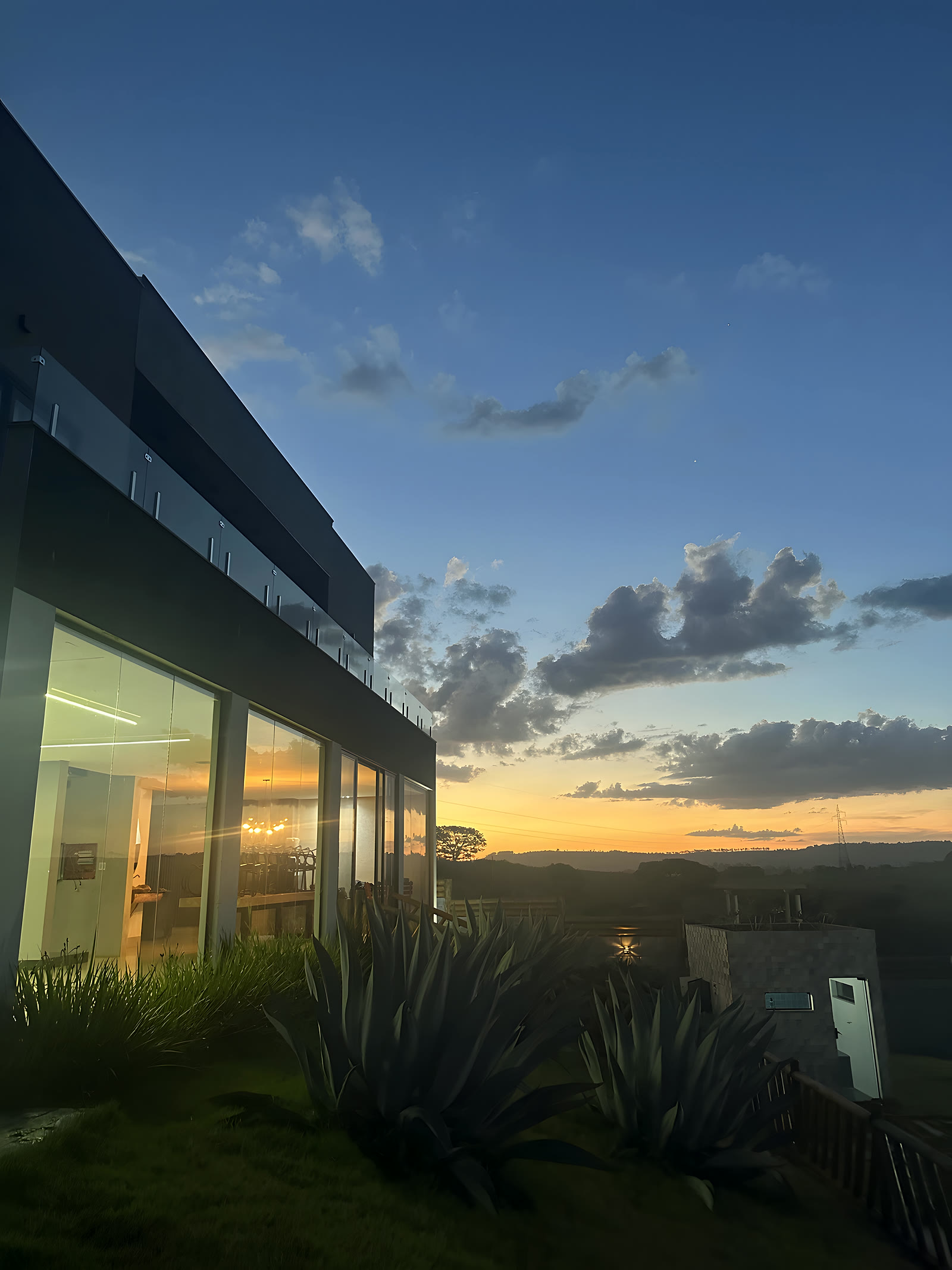 Fachada de vidro refletindo o céu do entardecer